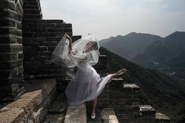 A model poses on the Great Wall of China during the Pierre Cardin China Legend 40th Anniversary Fashion Show on the outskirts of Beijing on September 20, 2018. (Photo by FRED DUFOUR / AFP) (Photo credit should read FRED DUFOUR / AFP via Getty Images )